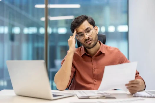 Leasehold property problems UK — frustrated flat owner reviewing lease documents and service charge statements at desk